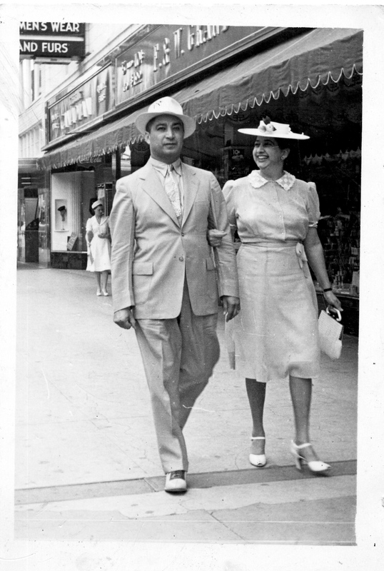 Black and white photograph of a couple walking down the street